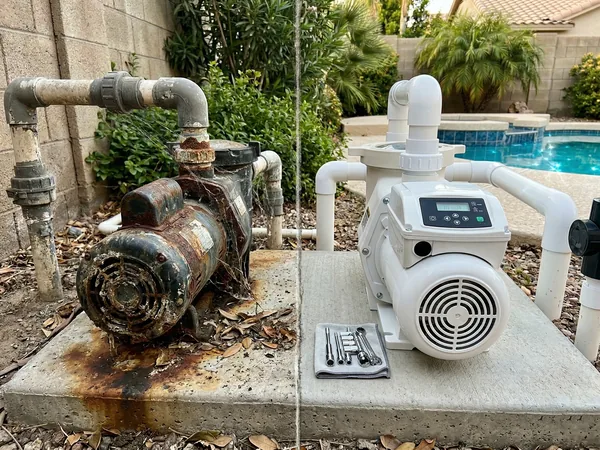 Old corroded pool pump next to a new variable-speed pump replacement on an equipment pad