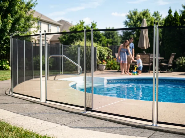 Black mesh removable safety fence installed around a residential inground pool